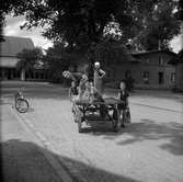 Barn på en kärra på Oxtorgsgatan i Jönköping. Bilden är tagen från öster mot Idrottshuset som tillfälligt utnyttjas som vandrarhem.