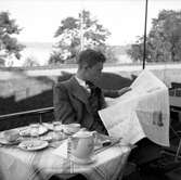 En ung man läser tidningen vid kaffebordet på Centralkonditoriet vid Östra Storgatan i Jönköping. Detta konditori var Tordarnas speciella mötesplats.