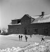 Utanför skolan i Sanna är en isbana spolad och barnen åker skridskor och spelar ishockey.