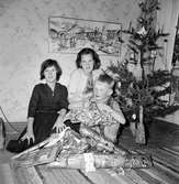 Julafton hos Toms farmor. Barnen som väntar vid julklappshögen är från vänster: Lillemor Johansson (1), Margareta Johansson (2) och Tom Andersson (3).