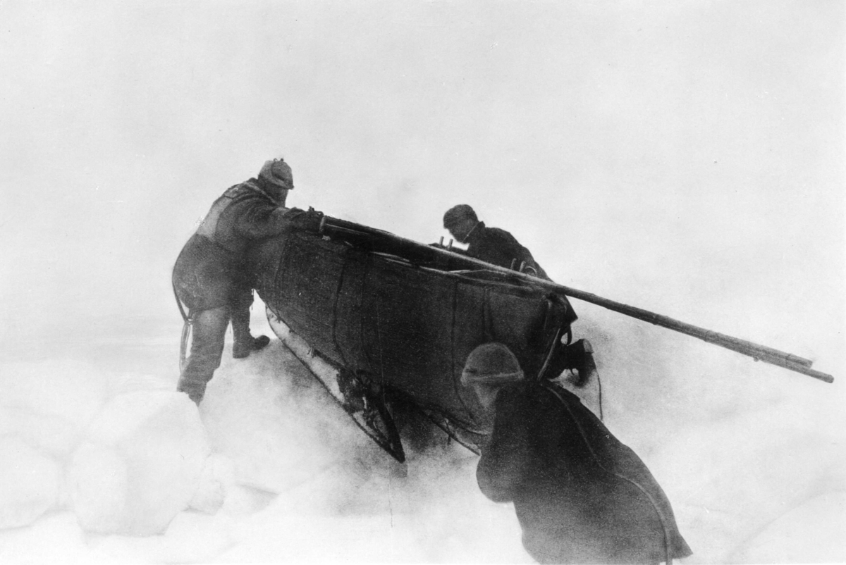 Nils Strindberg, Isvandringen. Alla tre skjuter på båten surrad på en släde. Nils Strindberg till höger om båten (sköter trådutlösningen), Knut Fraenkel till vänster och S A Andrée vid fören. Retuscherad version av gm.III-81.