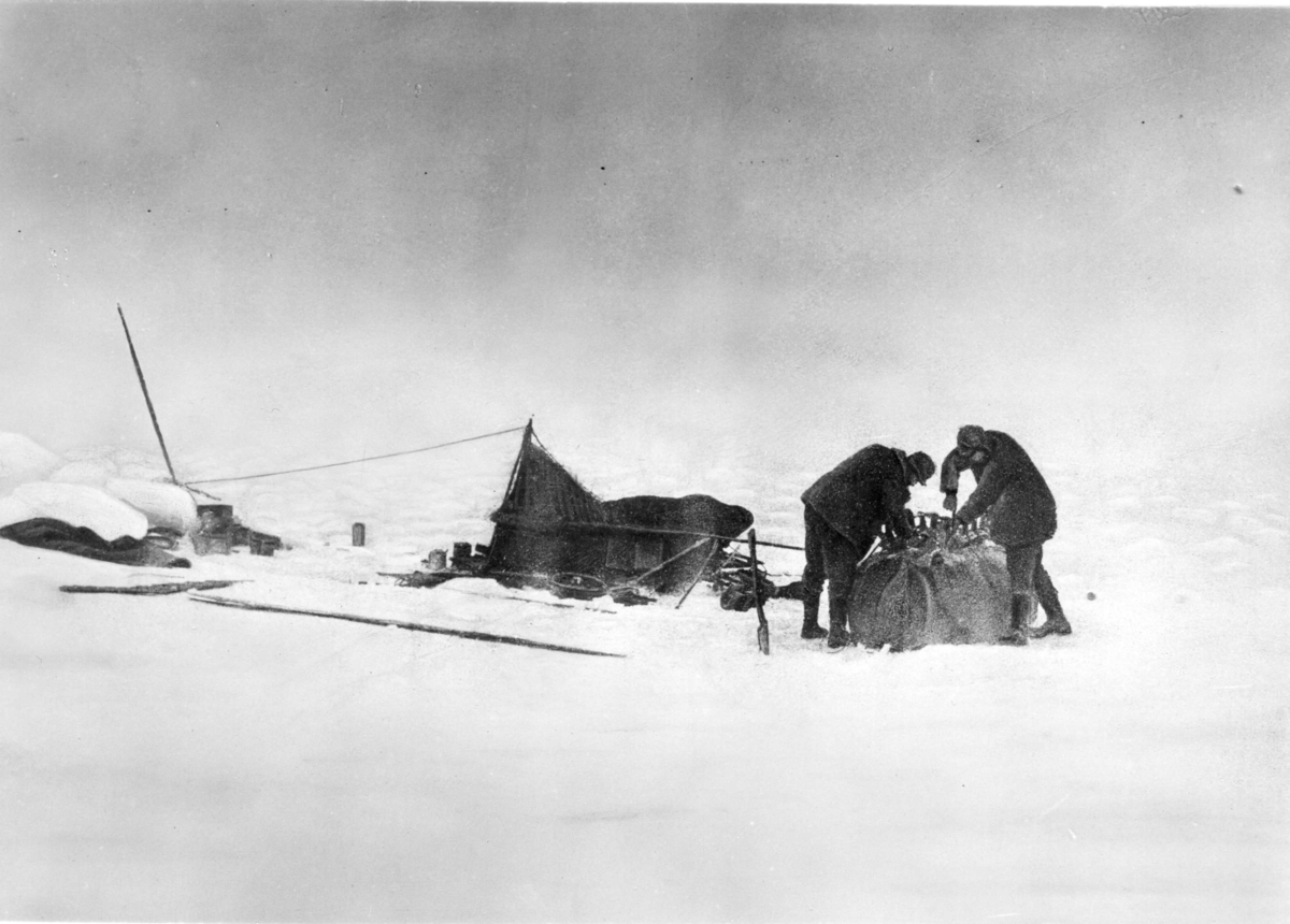 Nils Strindberg, The Ice Ring. S A Andrée on the left and Knut Fraenkel work on the sleigh sour at the upturned boat. The Tent on the left. Retouched variant of gm.III-82.