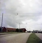 En Volvo och två Volkswagenbilar på vägen mellan Jönköping-Huskvarna innan den gjordes om till motorväg (E4:an). I bakgrunden syns höghusen på Österängen.