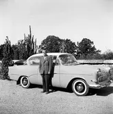 Sven Engvall står bredvid en bil, Opel Rekord, i Huskvarna.