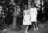 Systrarna Eva (född 1944, gift Kempe) och Karin Pettersson (född 1947, gift Hansson) står finklädda inför skolavslutning, Gamlehagsvägen 17 i Torrekulla år 1961. Döttrar till Bror 