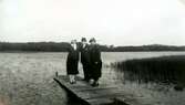 Tre personer står på en brygga vid Tulebosjön, 1930-tal. Från vänster: Okänd kvinna, Carl Krantz (1880 - 1956) och hustrun Eleonora Nora* Krantz (1879 - 1955).