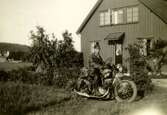 Östen Krantz (1910 - 1990) sitter på sin BSA-motorcykel utanför föräldrahemmet, cirka 1930. Föräldrarna Nora och Carl Krantz var båda anställda på Stretered och huset var deras personalbostad på Tulebovägen 23-27. Byggnaden finns kvar och ligger i backen ner mot Tulebo badplats. På vänster sida ses badplatsen till höger.
