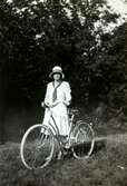 Iris Johansson (1913 - 2004, gift Persson) står med sin cykel i Livered, 1920-tal.
