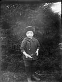 Liten pojke står framför en gran med ett papper i handen , Östhammar Uppland