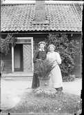 Kvinna står vid Ruth Skötsner ute på gårdsplanen med huset i bakgrunden, Östhammar Uppland