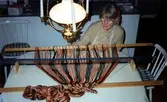 Emy Johansson arbetar hemma i sitt kök med väven till Kållereds Hembygdsdräkts sjal, Torrekulla 1980-tal. Relaterade motiv: A2911-A2917.