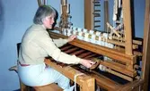 Emy Johansson arbetar hemma i sitt kök med väven till Kållereds Hembygdsdräkts sjal, Torrekulla 1980-tal. Relaterade motiv: Relaterade motiv: A2911-A2917.