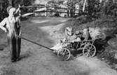 Göran Andersson drar Eva Pettersson (född 1944, gift Kempe) och Christer Andersson som sitter i en skrinda, Torrekulla år 1948.