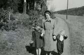Rosa Pettersson (1912 - 1994) och döttrarna Eva (född 1944, gift Kempe) samt Karin (född 1947, gift Hansson) promenerar på 