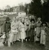 Påskklädda flickor och pojkar står i Torrekulla, cirka 1953 - 1956. Från vänster: 1. Dan Bernhardsson, 2. Monica Börjesson, 3. Lena Börjesson, 4. Karin Pettersson (född 1947), 5. Britt-Marie Larsson, 6. Eva Pettersson (född 1944), 7. Sven-Göran Olsson (född 1947), 8. Lisbeth Olsson och 9. Lennart Hillerström (född 1948).