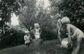 Fyra små flickor leker i familjen Petterssons trädgård på Gamlehagsvägen 17 i Torrekulla, år 1951. Från vänster: systrarna Eva (född 1944) och Karin Pettersson (född 1947) samt systrarna Monica och Lena Börjesson, döttrar till Britta (1919 - 1963) och Gunnar Börjesson (1916 - 1992) från Trollåsen i Torrekulla.