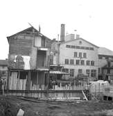 På Västra Storgatan 8 i Jönköping låg tidigare ett trähus som revs 1939 och ersattes av ett modernt stenhus. Här pågår grundarbeten för det så kallade Västerhuset, som skulle innehålla både affärer, kontor och bostadslägenheter. Byggnaderna i bakgrunden hör till Krönleins bryggeri, som revs 1970.
