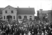 Utanför det stora Godsmagasinet till vänster om Järnvägsstationen i Jönköping har Nationalgodtemplarorden NGTO ett nykterhetsmöte. Magasinet blev busstation på 1950-talet.