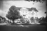 Vid Hovrättstorget i Jönköping står människor och väntar på spårvagnen från Rosenlund. I det gigantiska Grand Hotel som invigdes år 1904, finns förutom hotell även restaurang och teater.