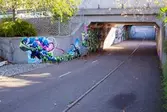 Tunnel med gång- och cykelbana i anslutning till Kållereds station. Målningar pryder tunnelns väggar. Fotografi taget den 6 oktober 2016.