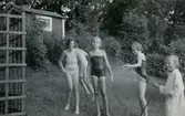 Tre flickor duschas med en trädgårdsslang av Karin Pettersson (född 1947, gift Hansson) på Gamlehagsvägen 17 i Torrekulla, år 1954. Från vänster: Barbro Lundberg, Inger Svensson, Eva Pettersson (född 1944, gift Kempe). Okänd som springer i bakgrunden.