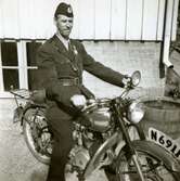 Fritiof (elev boende på Stretereds skolhem) iförd polisuniform, sitter på en motorcykel i Stretered, 1940-tal. Han fick 