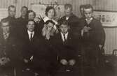 Julfirande vid arbetshemmet, för elever boende på Stretereds vårdhem år 1925. Nio män och två kvinnliga vårdarinnor står uppställda framför en julgran.