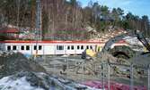 Vid byggandet av den nya Hallenskolan våren 2010. En grävmaskin gräver på den gamla skolgården. Området är stängslat för att undvika intrång. I bakgrunden ses gula, låga undervisningsbaracker samt Gunnar Erikssons röda tegelvilla på Hallavägen. Relaterade motiv: A2750 - A2754