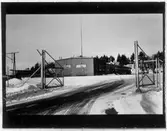 Vägstation B7, Åkersberga. Infarten med grindar till vägstationen. I bakgrunden huvudbyggnaden, med verkstadsdelen närmast.