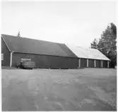 Vägstation C2, Bålsta. Förråds- och garagebyggnad. Framför förrådet en motorvält.