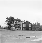 Vägstation C3, Kvarnbo. Byggnad, eventuell kontorsdel. Personbilar på garageplan, Volvo PV 444, bensinpumpar (drivmedelspumpar).