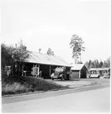 Vägstation C4, Björklinge. Garagebyggnad invid väg. Förrådsbyggnad och kontorsbyggnad i bakgrunden. Lastbil framför garaget.