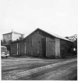 Vägstation D1, Närsjö. Filial Hållsta. Garage- och förrådsbyggnad. Bostadshus i bakgrunden, personbil.