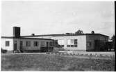 Vägstation D5, Flen. Vägstationens huvudbyggnad med Länsverkstadsdelen till höger. Smidesräcke med smidd text 