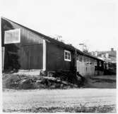 Vägstation D6, Björnlunda, filial Malmköping. Garagebyggnad med portar på långsidan. På en dörr målat 