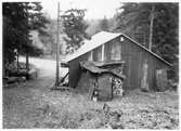 Vägstation D9, Vagnhärad, filial Tystberga. Garagebyggnad, med port på gaveln, delvis inbyggd i slänt. Slipstensbock. Upplag av bränslefat, upplag av ved, gengasved?