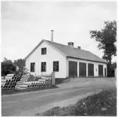 Vägstation E2, Kisa. Byggnad med  kontor och förråd i markplan, garageanläggning i souterrängvåning. Garage i markplan. Upplag av cementrör, muffrör. Invid väg.