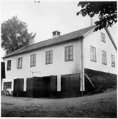 Vägstation E2, Kisa. Byggnad med  kontor och förråd i markplan, garageanläggning i souterrängvåning. Slipstenbock med slipsten.