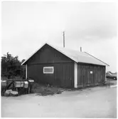 Vägstation Vmo E3, Boxholm, filial Backasand. Garagebyggnad. Invid väg. Postlådor till vänster.