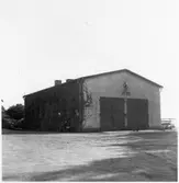 Vägstation E7, Fillinge. Garagebyggnad, reveterad,  med portar på gaveln. Ovanför portarna 