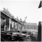 Vägstation E13, Stjärnvik. Garagelänga och förrådsbyggnad byggd i vinkel. Sten- och stubbrytare. Vägsladdar.