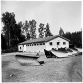 Vägstation E14, Simonstorp. Garagebyggnad med kontorsdel i byggnadens vänstra del. Spetsplogar på garageplan.