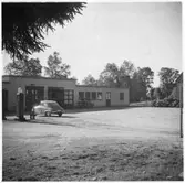 Vägstation G3, Vislanda. Stationsbyggnadens högra del med verkstad och kontor. Bensinpump (drivmedelspump) med personbil Saab, vid verkstaden liten lastbil (paketbil).