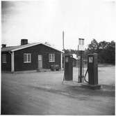 Vägstation G4, Bergsnäs, filial Räppe. Gaveln på garagedelen av huvudbyggnaden. Bensinpumpar (drivmedelspumpar).