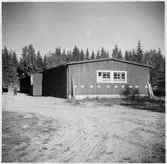 Vägstation G4, Bergsnäs, filial Räppe. Förrådsbyggnad. Mansperson i bakgrunden.