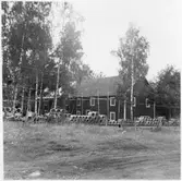 Vägstation G7, Ingelstad. Förrådsbyggnad i två våningar. Arbete pågår med nytt tegeltak, byggnadsställningar på framsidan. Upplag av cementrör och muffrör.