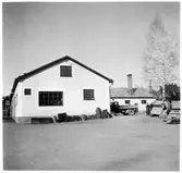 Vägstation H5, Vimmerby. Vinkelbyggnad, troligen innehållande garage- och förrådsbyggnad. Lastbil och stenkross.