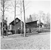 Vägstation H5, Vimmerby. Förrådsbyggnader, innanför trästaket. Sandficka till vänster.