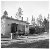 Vägstation H9, Nybro. Vägstationens huvudbyggnad med verkstadsdel, kontorsdel och garagedel. Soptunna framför verkstaden.