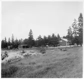 Vägstation I5, Stånga. Översikt över området med garagebyggnad, förrådsbyggnader. Manskapsvagn ÅSA transportabla manskapsbod, Åmåls Sågverks AB, längst till vänster. Sidoplogar och spetsplogar.